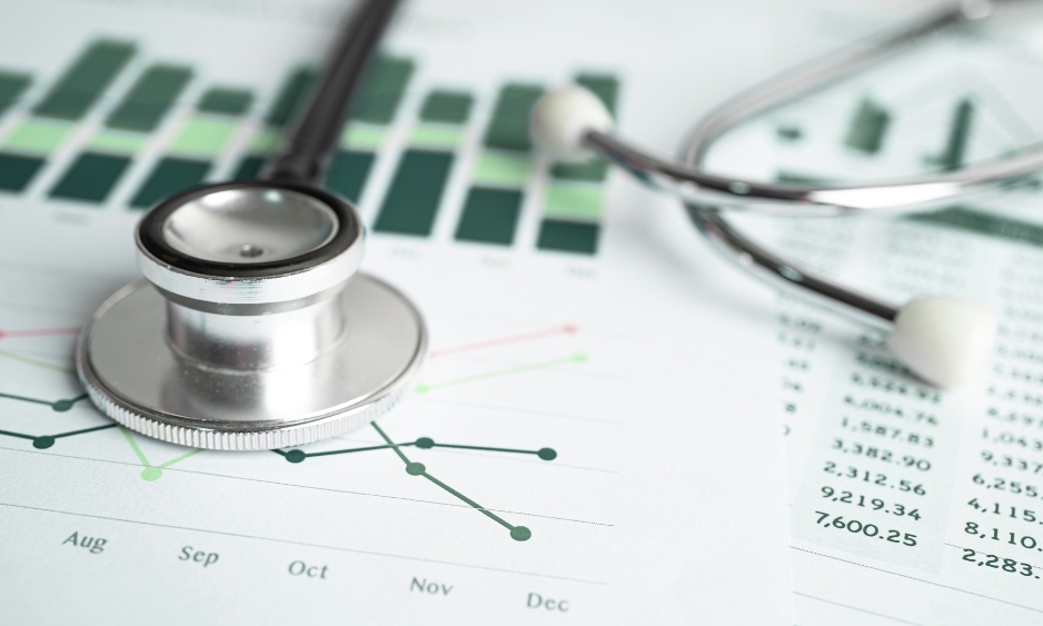 A stethoscope resting on printed charts and data tables